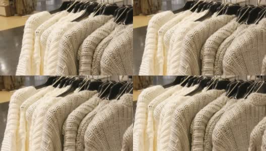 漂亮的女人编织的浅色毛衣挂在服装店的衣架上高清在线视频素材下载
