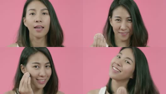 年轻美丽时尚的亚洲女人用化妆刷在休闲服装粉妆在粉红色的背景工作室拍摄。快乐的微笑可爱的快乐的女人庆祝成功。高清在线视频素材下载