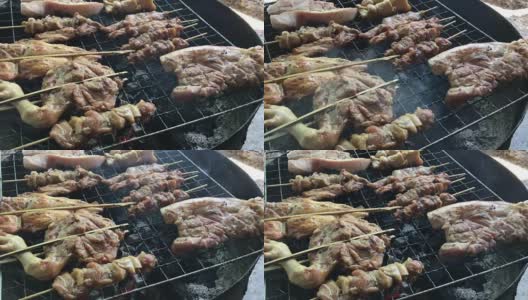 泰式街头小吃:炭火烤鸡，猪肉放在炉上半切油罐用烟熏。泰国风格的食物。泰式烧烤或“Moo Ping”在泰国字。4K视频高清在线视频素材下载