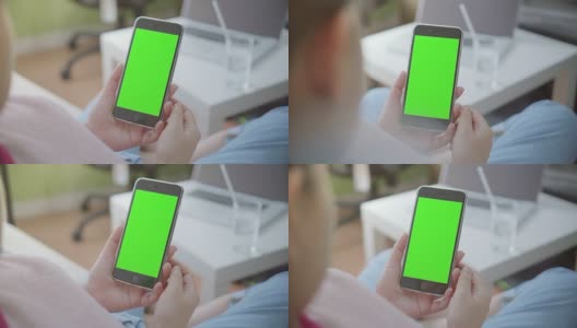 过肩拍摄的女性使用智能手机，绿色屏幕高清在线视频素材下载