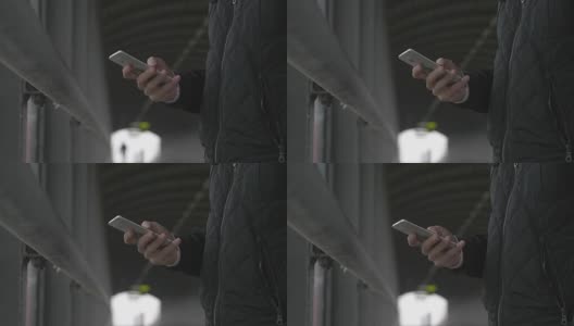 一个男人在人行桥上使用智能手机的特写高清在线视频素材下载