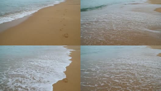 沙滩上的新脚印被海浪冲走了。高清在线视频素材下载