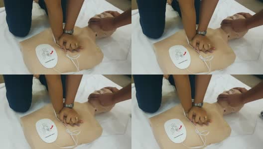 学生在心肺复苏训练班学习如何使用心肺复苏娃娃和AED机抢救紧急情况下的病人高清在线视频素材下载