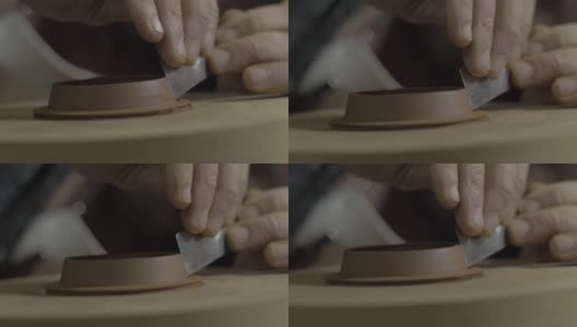 师傅用金属工具从宜兴陶土中取出壶盖上多余的陶土。茶道用手工陶壶。褐色陶器茶壶。4 k的视频。59.94帧/秒高清在线视频素材下载