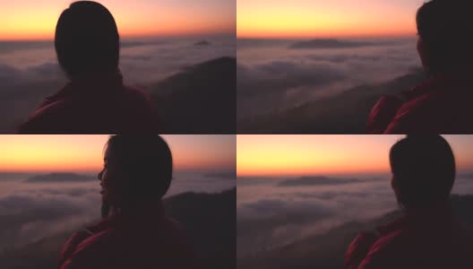 年轻女子看着山上的风景与阳光和雾。带着相机独自旅行的背包客。假日旅游和度假概念。高清在线视频素材下载