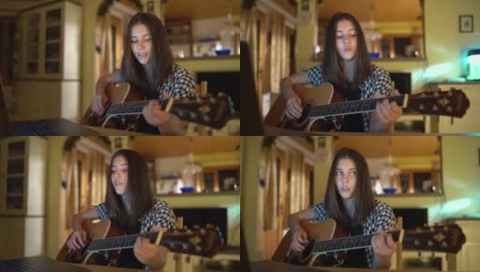 年轻的女孩玩吉他和唱歌在晚上高清在线视频素材下载
