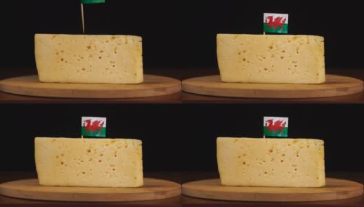 男人的手把一小块有威尔士旗的牙签放在奶酪上。高清在线视频素材下载