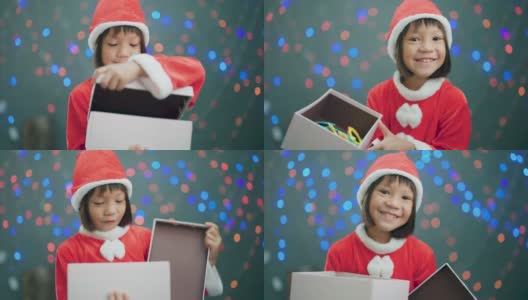 女孩穿着圣诞老人的衣服打开礼品盒。高清在线视频素材下载