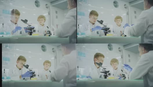 好奇的男孩在实验室工作。使用显微镜和准备实验。和父亲一起学习，传递样本高清在线视频素材下载