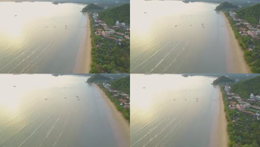 航拍:在海滨度假胜地上空飞行，人们在海滩上散步。高清在线视频素材下载