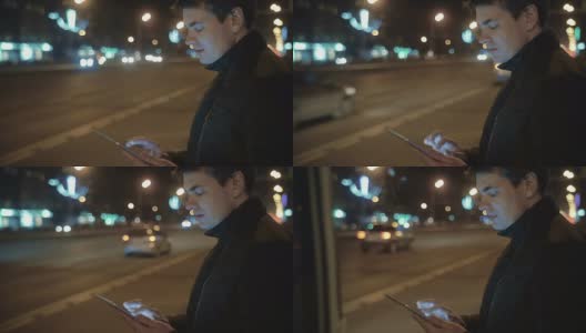 一名男子在等公交车时用平板电脑写信高清在线视频素材下载