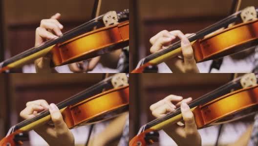 一个年轻的小提琴手模糊的左手按下小提琴颈上的弦，水平高清在线视频素材下载
