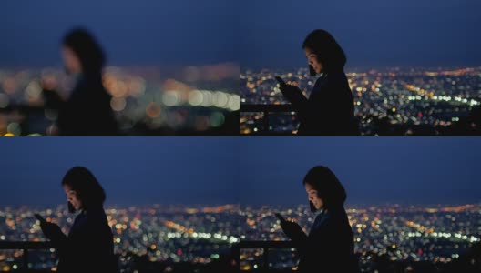 女人用智能手机与城市灯光散景，圈光背景高清在线视频素材下载