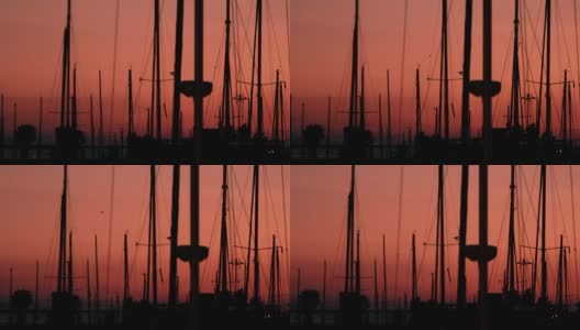 游艇剪影的背景黄昏日落在海上。游艇港口和小艇桅杆高清在线视频素材下载