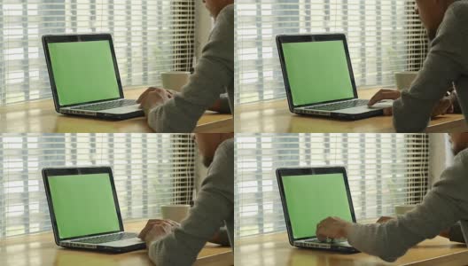 一个人在绿色屏幕的笔记本电脑键盘上打字高清在线视频素材下载
