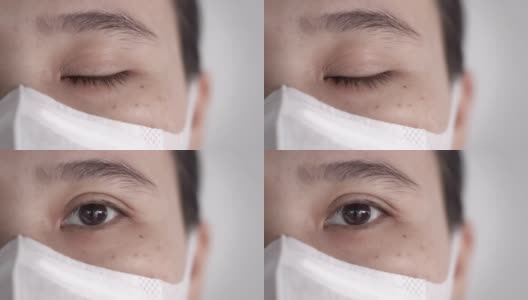 特写亚洲妇女的眼睛与卫生口罩或医疗口罩看着相机高清在线视频素材下载