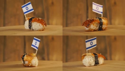 寿司配上鱼、米饭、海草和以色列小旗放在上面，在一个木制的转盘上旋转。高清在线视频素材下载
