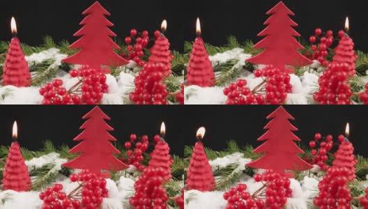 圣诞节的静物与红色的荚莲浆果，圣诞树，燃烧的蜡烛和雪在黑色的背景高清在线视频素材下载