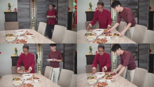 在中国新年期间，亚裔中国老人和他的儿子从厨房拿食物放在餐桌上高清在线视频素材下载