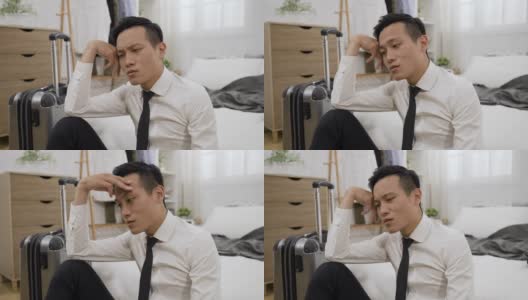 一个沮丧的亚洲企业家在家里的卧室里感到困惑和担心的时候，用叹息支撑着他的头高清在线视频素材下载