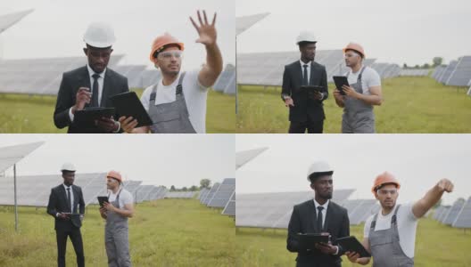 非裔美国检查员手里拿着平板电脑给印度技术人员讲解太阳能工厂的工作。生态工程和替代能源概念。和技术人员谈论太阳能电池板高清在线视频素材下载