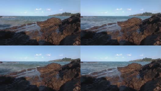 在非常低的水平上拍摄的小海浪击碎岩石的视频高清在线视频素材下载