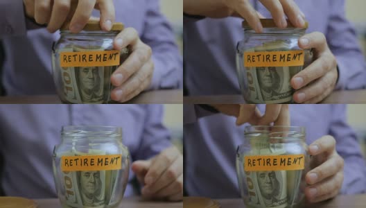 一个白种男人把一个玻璃罐放在抽屉里和他未来退休的积蓄放在一起高清在线视频素材下载