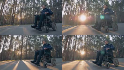 一个残疾人正坐在电动轮椅上沿着道路行进高清在线视频素材下载
