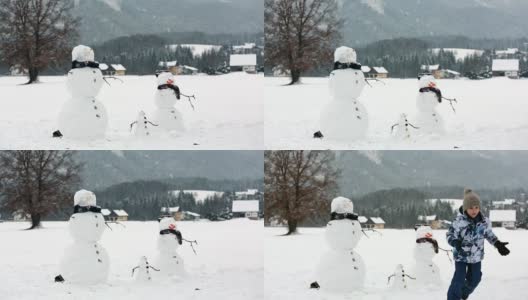 一家人带着孩子，在奥地利小村庄的公园里堆雪人，风景秀丽。高清在线视频素材下载