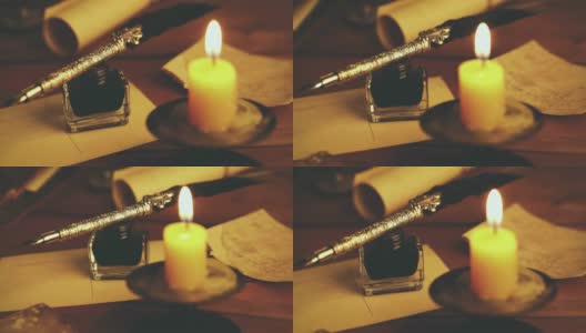 棕色木桌上放着老式羽毛笔和墨水瓶，桌上还放着蜡烛高清在线视频素材下载
