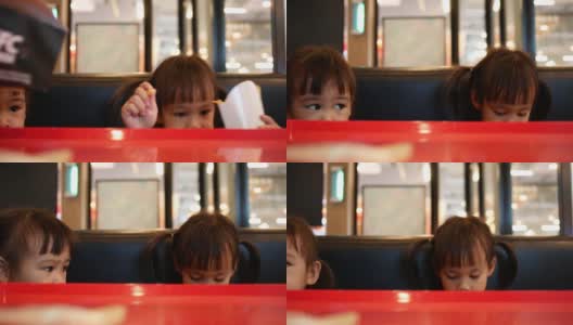 快乐的亚洲小女孩和她的妹妹在餐厅吃薯条。保健和食品理念。高清在线视频素材下载