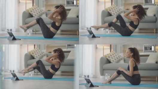 一名年轻女子在家练瑜伽时使用电子平板电脑的4k视频片段高清在线视频素材下载