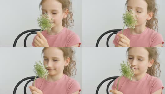 小女孩坐在家里，手里拿着花在夏天的时间和打喷嚏，过敏，哮喘，或过敏的概念高清在线视频素材下载