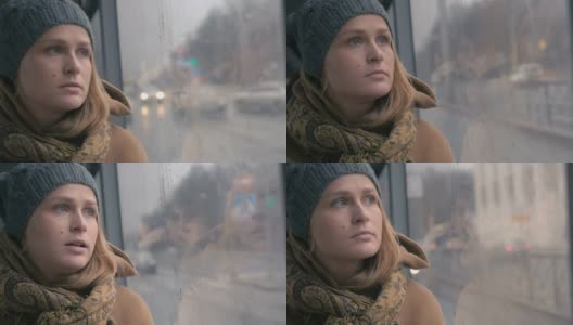 在一个沉闷的雨天，公交车上的一个悲伤的年轻女人高清在线视频素材下载