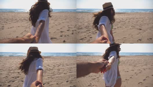 一个面目全非的女孩牵着一个男人的手在海滩上奔向大海。跟着我拍的年轻女子戴着帽子拉她的男朋友在海边。暑假或假日概念。观点慢动作高清在线视频素材下载