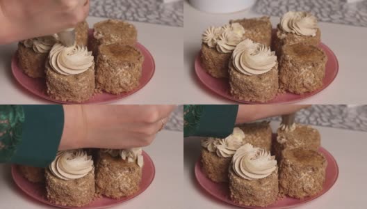 一位女士用奶油和饼干屑做海绵蛋糕。用糕点袋装饰奶油。特写镜头高清在线视频素材下载