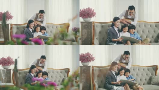 亚洲母亲和父亲读书与儿子和女儿在家里高清在线视频素材下载