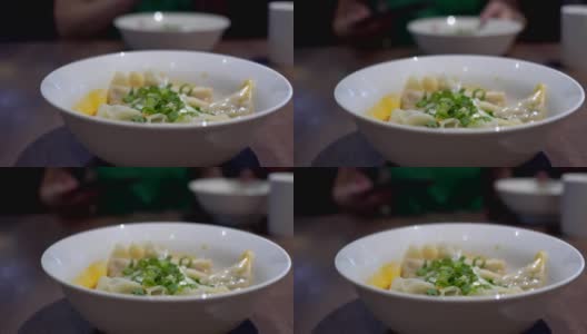 在一家亚洲餐馆里，母亲和孩子用筷子吃饺子。味道很辣。高清在线视频素材下载
