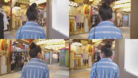 迷人的亚洲女性戴着口罩防护冠状病毒的新常态生活方式，在商场超市购物背景下行走高清在线视频素材下载