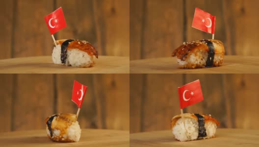 寿司配上鱼、米饭、海草和土耳其小旗放在上面，在木制的转盘上旋转。高清在线视频素材下载