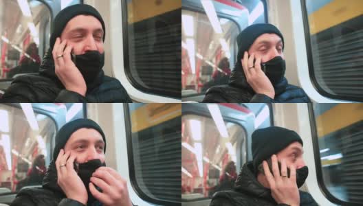 蒙面男乘客在地铁车厢里打电话。他把小玩意儿放在耳朵上。高清在线视频素材下载