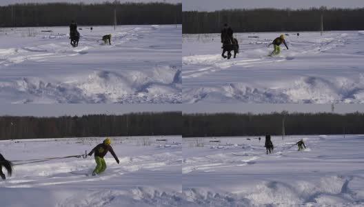 慢镜头:一个女孩骑着马疾驰。一匹马用绳子拖着一个滑雪者。滑雪者在雪堆中骑在滑雪板上。女子骑师和男子滑雪板训练成对。高清在线视频素材下载