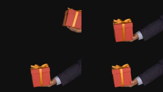 一个穿着西装的男人手里拿着一个红色礼品盒，上面有一个金色的蝴蝶结。手与礼物出现在相框中。红色的礼盒。商人送礼物。Alpha通道色度键透明背景。高清在线视频素材下载