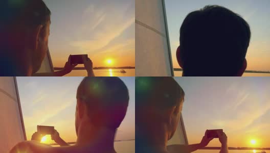 一名男子在游艇上用手机拍摄海上令人惊叹的日落慢镜头。高清在线视频素材下载