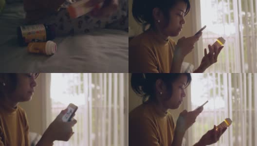 年轻的亚洲女人拿着药瓶，在卧室里讲手机高清在线视频素材下载