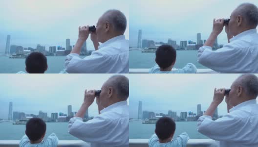 爷爷和孙子用望远镜看香港的天际线高清在线视频素材下载