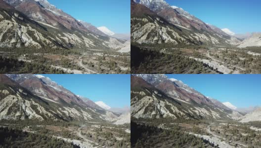 一条穿过尼泊尔喜马拉雅山马南谷森林的小路。安纳普尔纳的尖峰和贫瘠的山峰在后面。安纳普尔纳峰电路长途跋涉。大自然的美。尘土飞扬的道路。高清在线视频素材下载