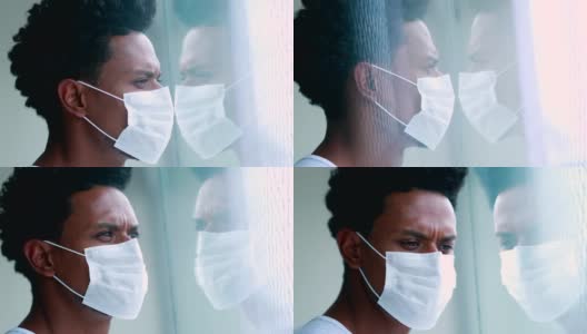 非洲黑人戴着防毒面具望着窗外，玻璃脸反射高清在线视频素材下载