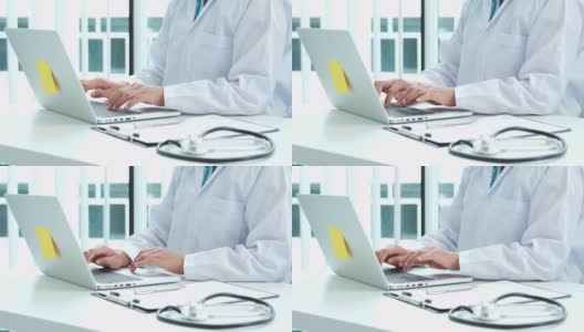 一名年轻的亚洲医生在医院用笔记本电脑工作的4K视频高清在线视频素材下载