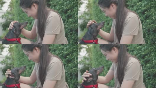 一个东南亚妇女在后院和她的狗玩高清在线视频素材下载